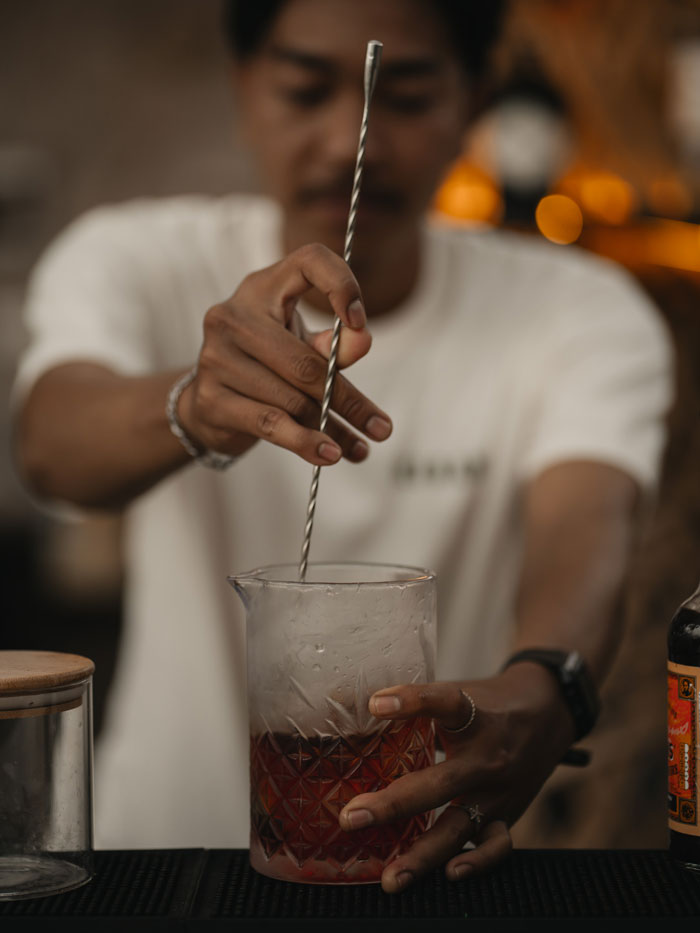 Bartender crafting a signature cocktail at Kaban Bali restaurant and bar
