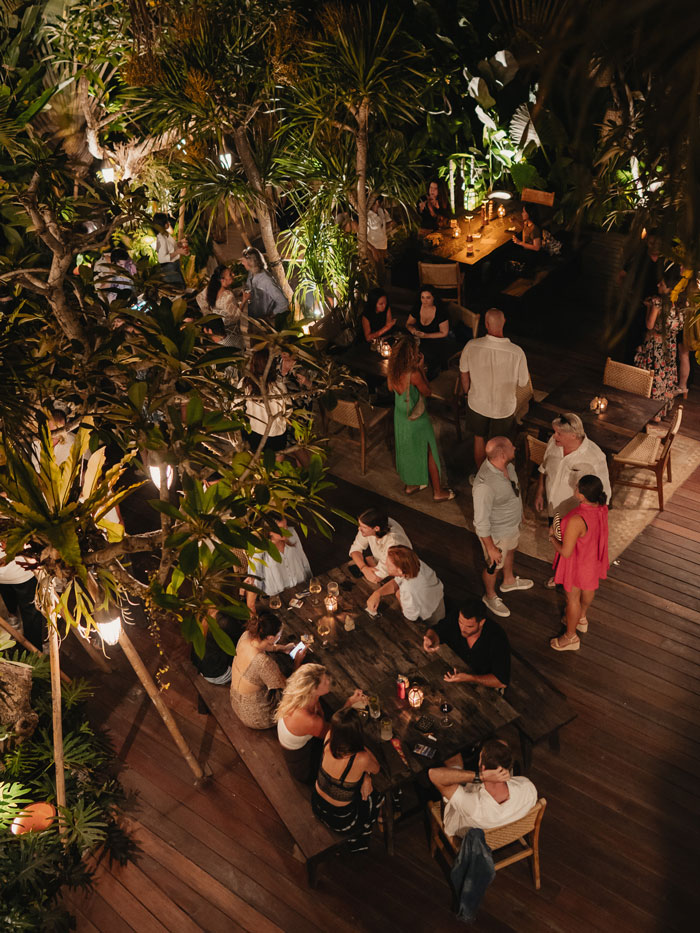 Friends and visitors enjoying cocktails, laughter, and music at the KABAN Restaurant Bali opening celebration.
